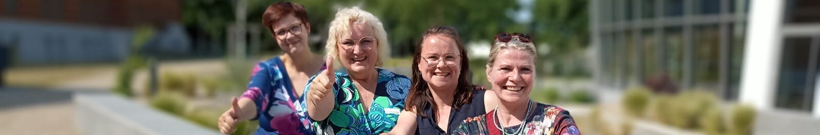 Vier Frauen, die nebeneinander sitzen.